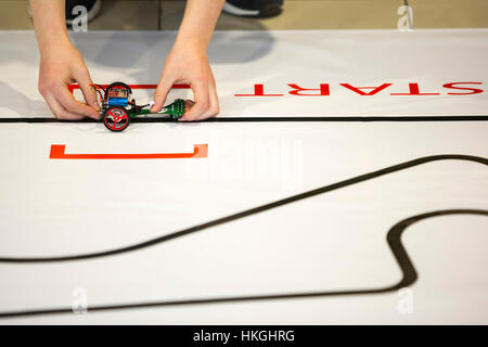 Sofia, Bulgaria - December 17, 2016: A student prepares his race robot during an open competition of self-made robots among school students. Stock Photo