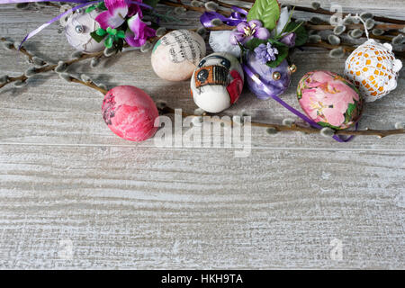 Decoupage decorated colorful Easter eggs with willow branches on wooden table Stock Photo