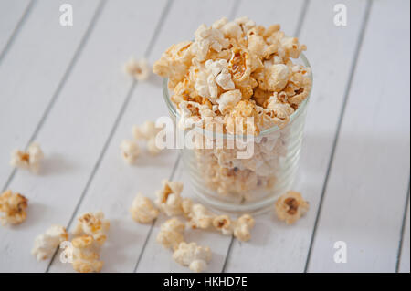 Popcorn in glass cup on white background Stock Photo