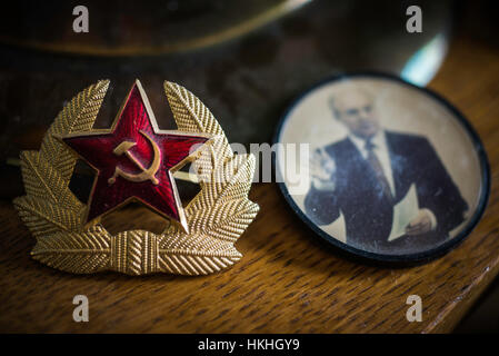 Communist symbols and items. Gorbachev button, Saddam Hussein playing identity cards and Matryoshka Nesting Dolls, Boris Yeltsin. Stock Photo