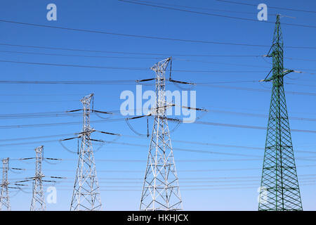 Group of high voltage towers under blue sky Stock Photo