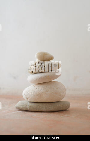 A stack of pebbles with light tones against a rustic background Stock Photo