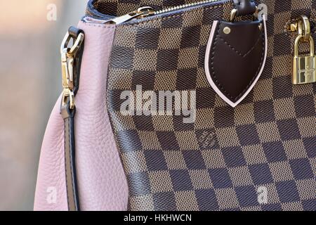 A Louis Vuitton handbag on a bed with a blue sheet Stock Photo - Alamy