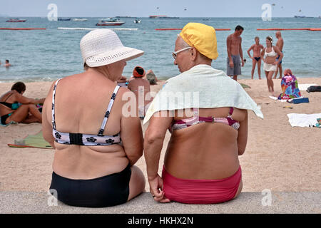 Amusing image reminiscent of the 1950s UK postcards with two mature ladies at the seaside. Stock Photo