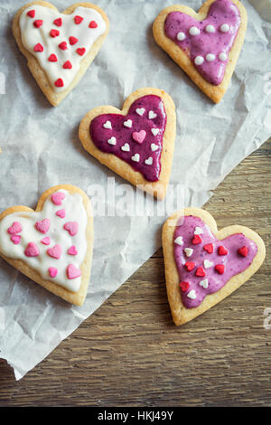 Heart shaped cookies close up for Valentine day - homemade festive decorated pastry buiscuits cookies on baking paper, valentine love concept Stock Photo