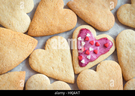 Glazed heart shaped cookies for Valentine's day with text With Love - delicious homemade natural organic pastry, baking with love for Valentine's day, Stock Photo