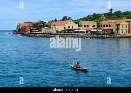 Fisherman in canoe, slave island in back, Île de Gorée, Dakar, Senegal Stock Photo