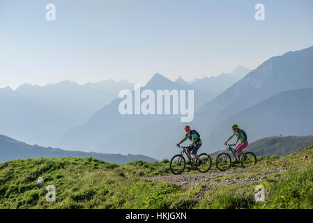 Two mountain biker friends riding on uphill, Zillertal, Tyrol, Austria Stock Photo