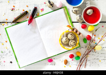 Cooking recipe background for Easter celebration: quail eggs are, candy and twigs of willow on a white background, top view, copy space. Food backgrou Stock Photo