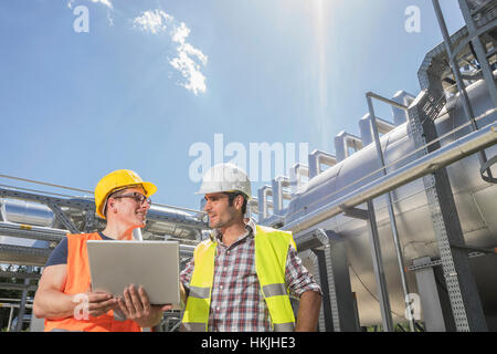 Engineer with his colleague in meeting with laptop at geothermal power station, Bavaria, Germany Stock Photo
