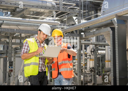 Engineer with his colleague in meeting with laptop at geothermal power station, Bavaria, Germany Stock Photo