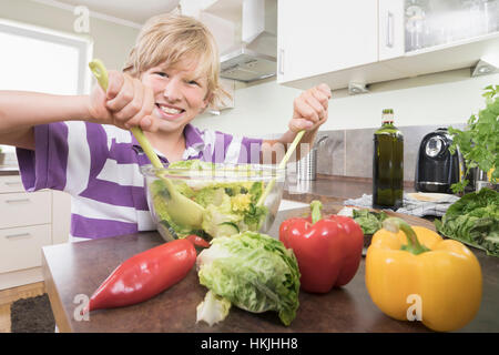 Portrait of a boy preparing salad in kitchen,Bavaria,Germany Stock Photo
