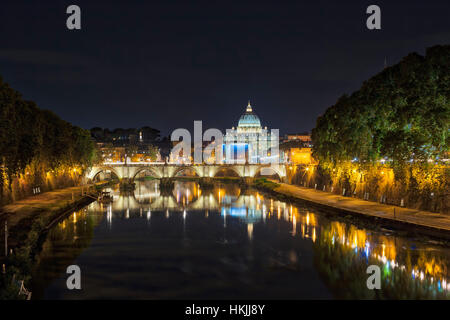 Illuminated St. Peter's Basilica by bridge over river at night, Rome, Italy