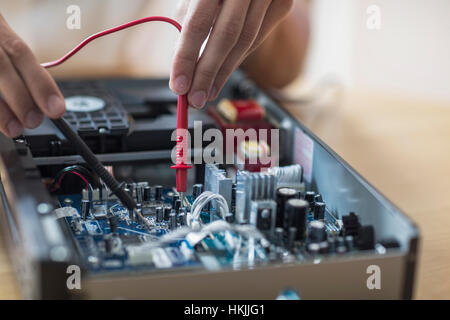 Engineer repairing CD player in workshop, Freiburg Im Breisgau, Baden-Württemberg, Germany Stock Photo