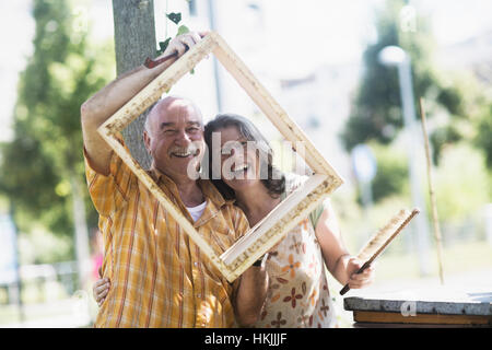 Portrait of beekeepers holding crate and smiling, Freiburg im Breisgau, Baden-Württemberg, Germany Stock Photo