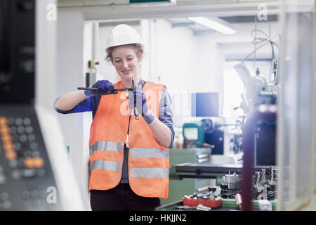 Young female engineer repairing machine part in an industrial plant, Freiburg im Breisgau, Baden-Württemberg, Germany Stock Photo