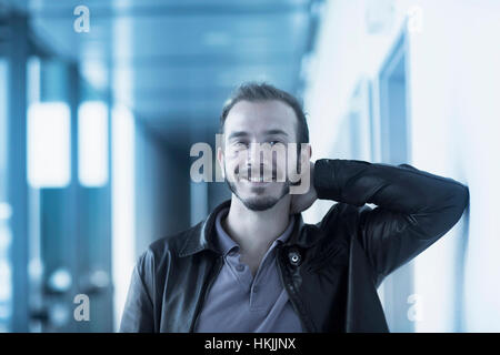 Portrait of a young male engineer in technology space and smiling, Freiburg Im Breisgau, Baden-Württemberg, Germany Stock Photo