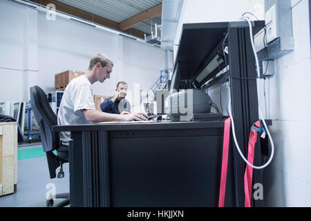 Store workers working on desktop pc, Freiburg im Breisgau, Baden-Württemberg, Germany Stock Photo