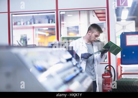 Male engineer examining circuit board in industry,Hanover,Lower Saxony,Germany Stock Photo