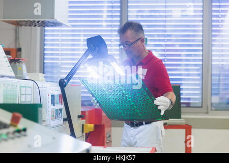 Male engineer examining circuit board in industry,Hanover,Lower Saxony,Germany Stock Photo