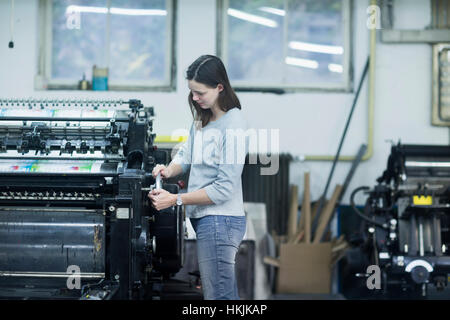 Print worker adjusting printing machine in an industry, Freiburg im Breisgau, Baden-Württemberg, Germany Stock Photo