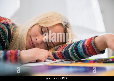Exhausted student sleeping during doing homework in the living room, Bavaria, Germany Stock Photo