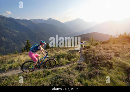 Two mountain bikers riding on hill in alpine landscape, Zillertal, Tyrol, Austria Stock Photo