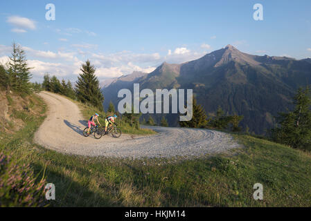 Two mountain bikers riding on dirt track in alpine landscape, Zillertal, Tyrol, Austria Stock Photo