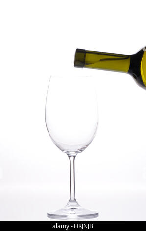 pouring white wine from bottle in empty glass Stock Photo