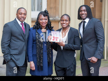 Nicola Adams with her family, uncle Robert Ottley (left) mother Denver Adams and brother Kurtis Adams (right) after receiving her Member of the British Empire MBE medal from Queen Elizabeth II during an Investiture ceremony at Buckingham Palace in London. Stock Photo