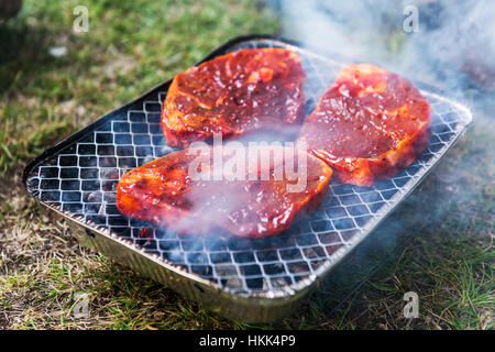 striped mutton steak on non-permanent foil grill closeup Stock Photo
