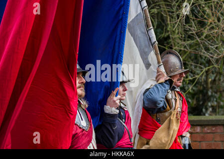 Cheshire, UK. 28th Jan, 2017.  Battle Flags fly on Holly Holy Day & Siege of Nantwich re-enactment. For over 40 years the faithful troops of The Sealed Knot have gathered in the historic town for a spectacular re-enactment of the bloody battle that took place almost 400 years ago and marked the end of the long and painful siege of the town. Roundheads, cavaliers, and other historic entertainers converged upon the town centre to re-enact the Battle. The siege in January 1644 was one of the key conflicts of the English Civil War. Stock Photo