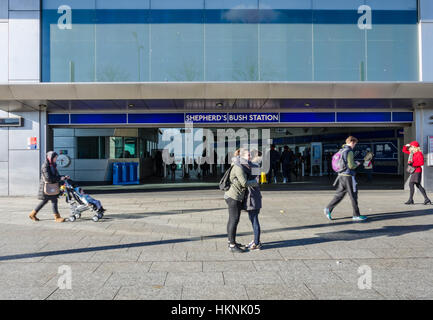 Friends meet and embrace outside Shepherds Bush London Underground station. Stock Photo