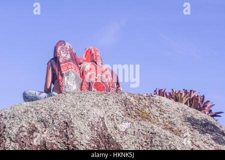 Ilhabela, Brazil, Two young people sit on top of a rock Stock Photo