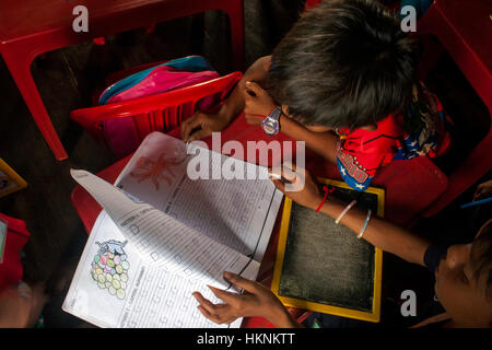 Two Asian boys are studying an English language text book at an English language school in Chok Village,  Tboung Khmum Province, Cambodia. Stock Photo