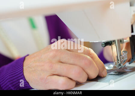 Closeup of female using sewing machine Stock Photo