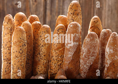 Different types of baguettes in metal basket in bakery with empty space for text Stock Photo
