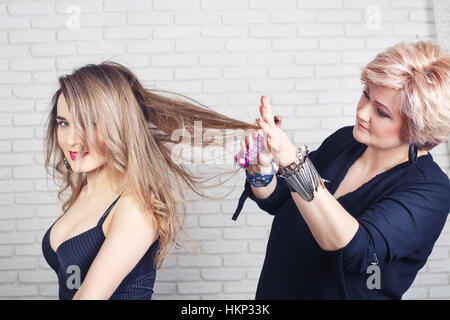 Hairdresser using  hairspray Stock Photo