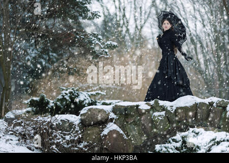 Woman in black Victorian dress in the winter park Stock Photo