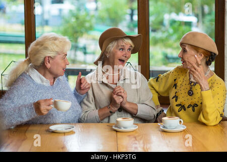 Three senior ladies drinking coffee. Stock Photo