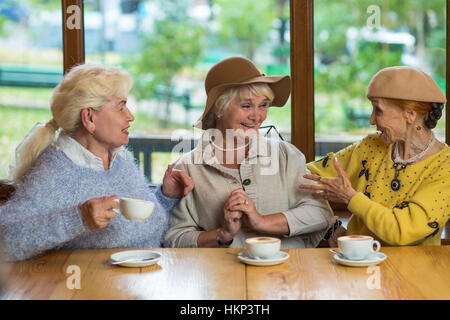 Three elderly ladies drinking coffee. Stock Photo