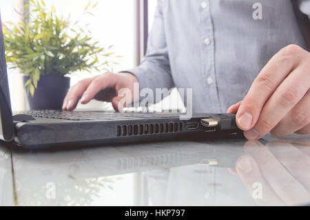 Man is connecting black hdmi cable into laptop Stock Photo
