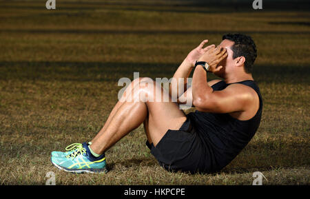 sport man exercising abs on grass park Stock Photo