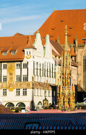 View across Christmas market stalls to Schoene Brunnen or Beautiful Fountain in Hauptmarkt Square. Nuremberg, Bavaria, Germany Stock Photo