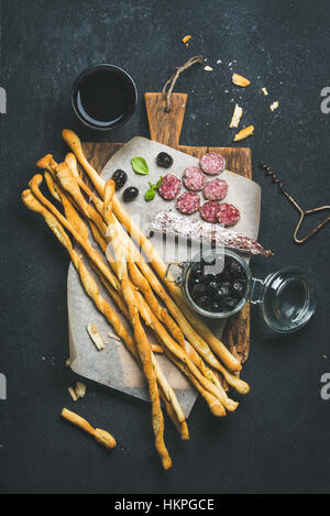 Wine and appetizers set with grissini, sausage, black olives Stock Photo