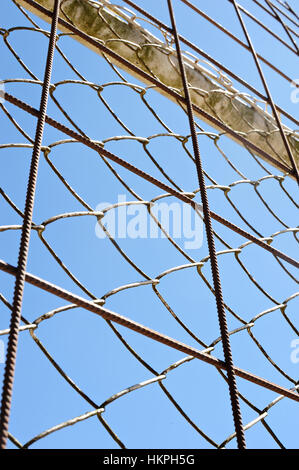 metal mesh net fence on blue sky background Stock Photo