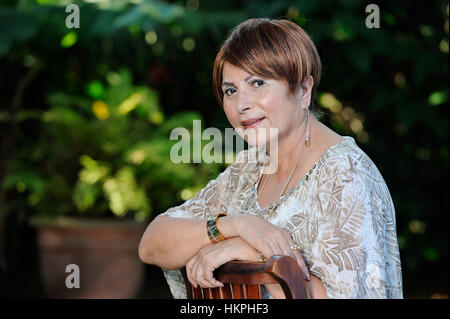 good looking old smiling lady in green garden Stock Photo