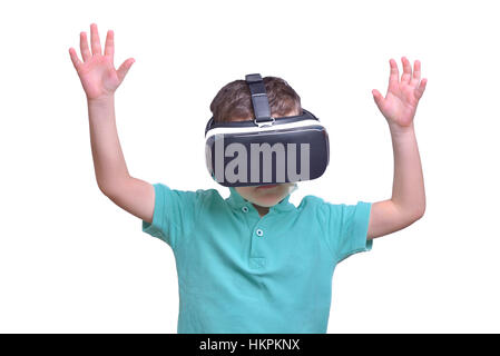 Amazed teen boy wearing virtual reality goggles watching movies or playing video games, isolated on white. Surprised teenager looking in VR glasses. Stock Photo