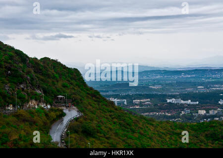 Scenic road with curves through Margalla Hills with capital city in the background. Stock Photo