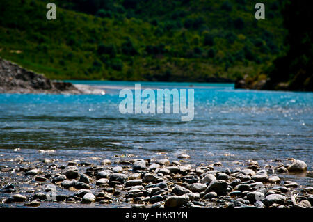 Lake side coast view with mountain background during a bright sunny day Stock Photo